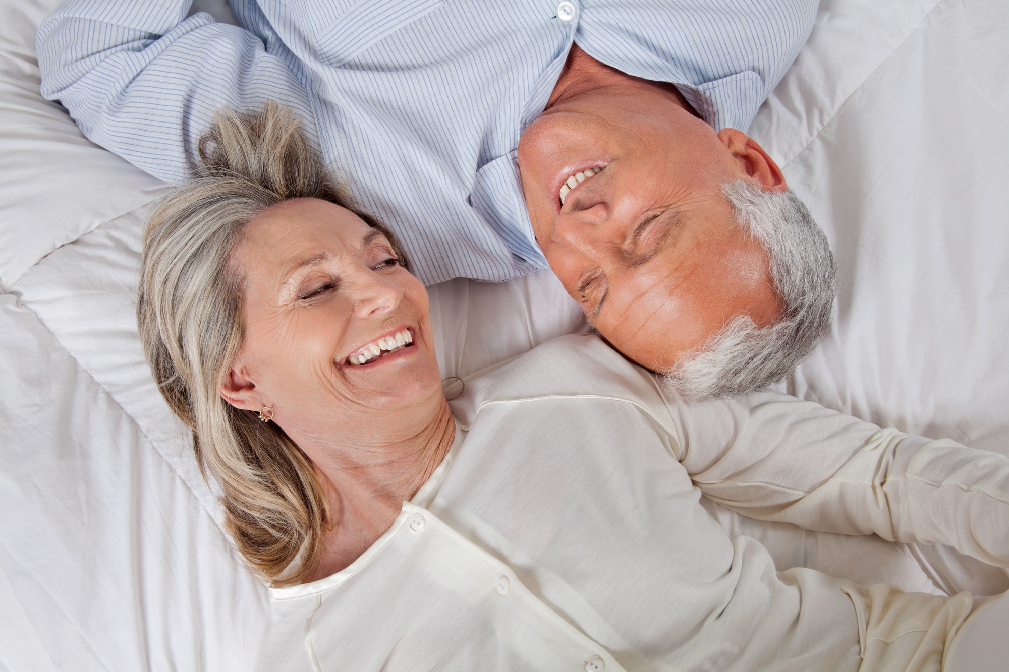 Top view of happy couple lying in bed